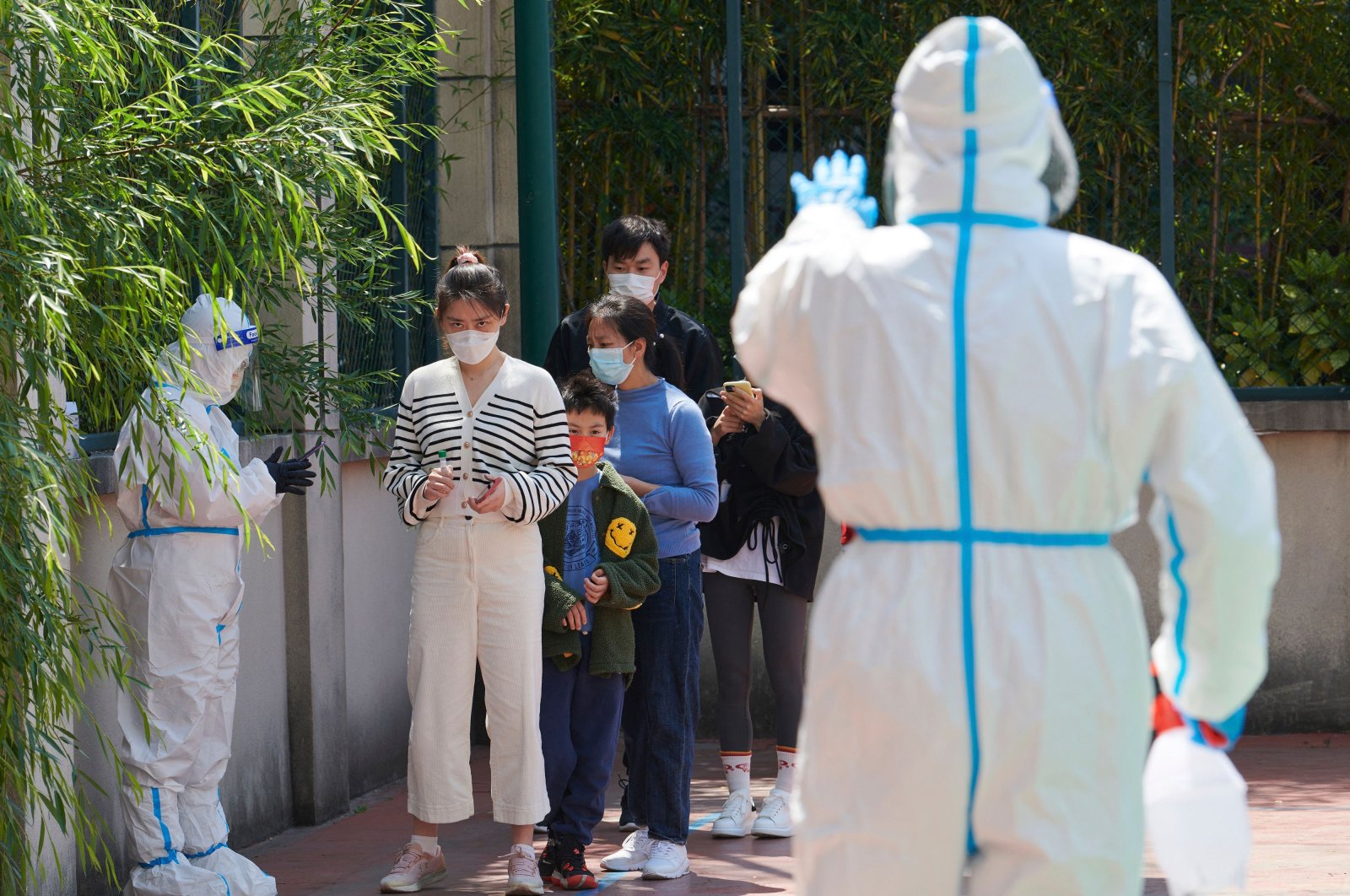 Community volunteers wearing personal protective equipment guide residents queuing to get tested for COVID-19 in a compound during a lockdown in Pudong district, Shanghai, China, April 17, 2022. (AFP Photo)