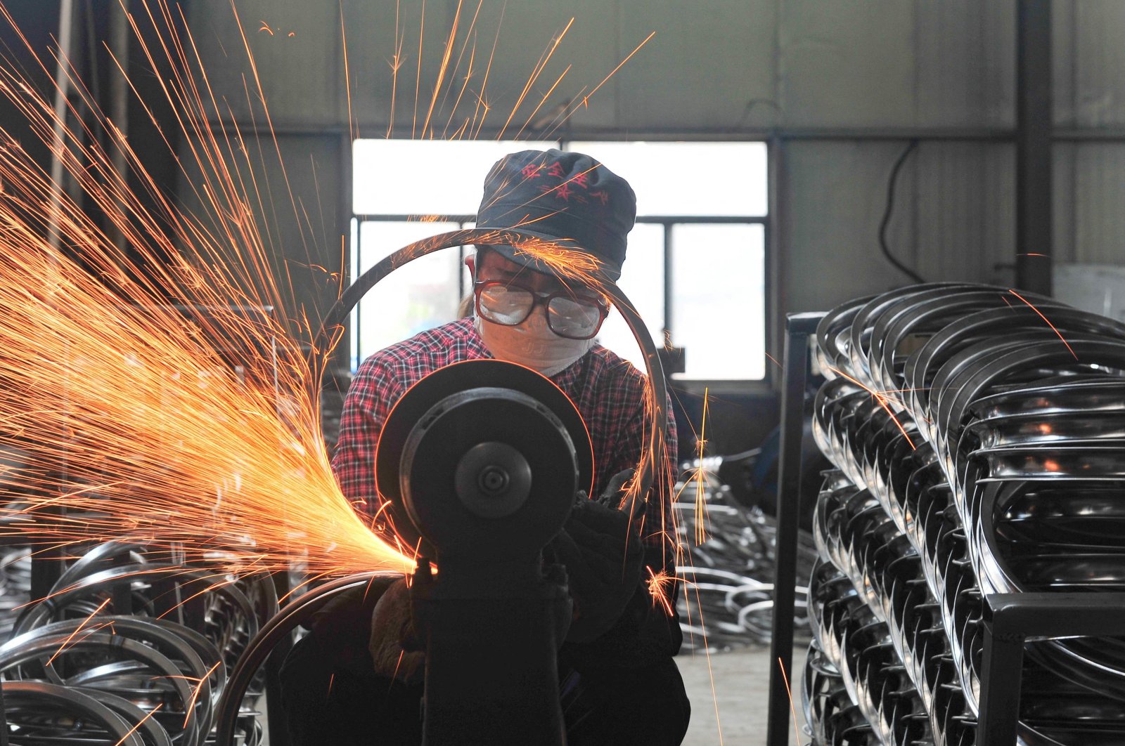 A worker welds wheels at a factory in Hangzhou in China&#039;s eastern Zhejiang province, April 17, 2022. (AFP Photo)
