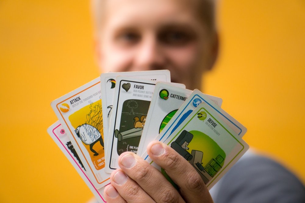 A man holds &quot;Exploding Kittens&quot; cards, Bogota, Colombia, July 25, 2019. (Shutterstock Photo)