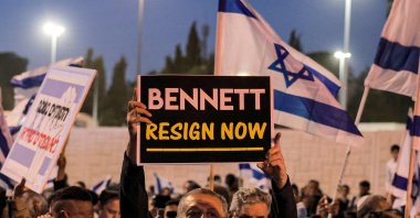 A man holds up a sign reading in English "(Israeli Prime Minister Naftali) Bennett resign now" during an anti-government protest by Israeli right-wing supporters in Jerusalem, April 6, 2022. (AFP Photo)