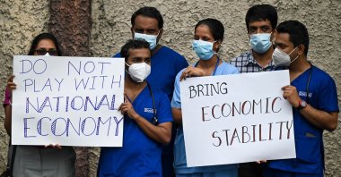 Doctors and nurses of the Lady Ridgeway Children's hospital hold placards during a silent demonstration against shortages of medicines in Colombo, Sri Lanka, April 19, 2022. (AFP Photo)