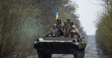 Ukrainian servicemen ride atop an armored fighting vehicle, as Russia's attack on Ukraine continues, at an unknown location in eastern Ukraine, in this handout picture released April 19, 2022.  (Press service of the Ukrainian Ground Forces/Handout via Reuters)