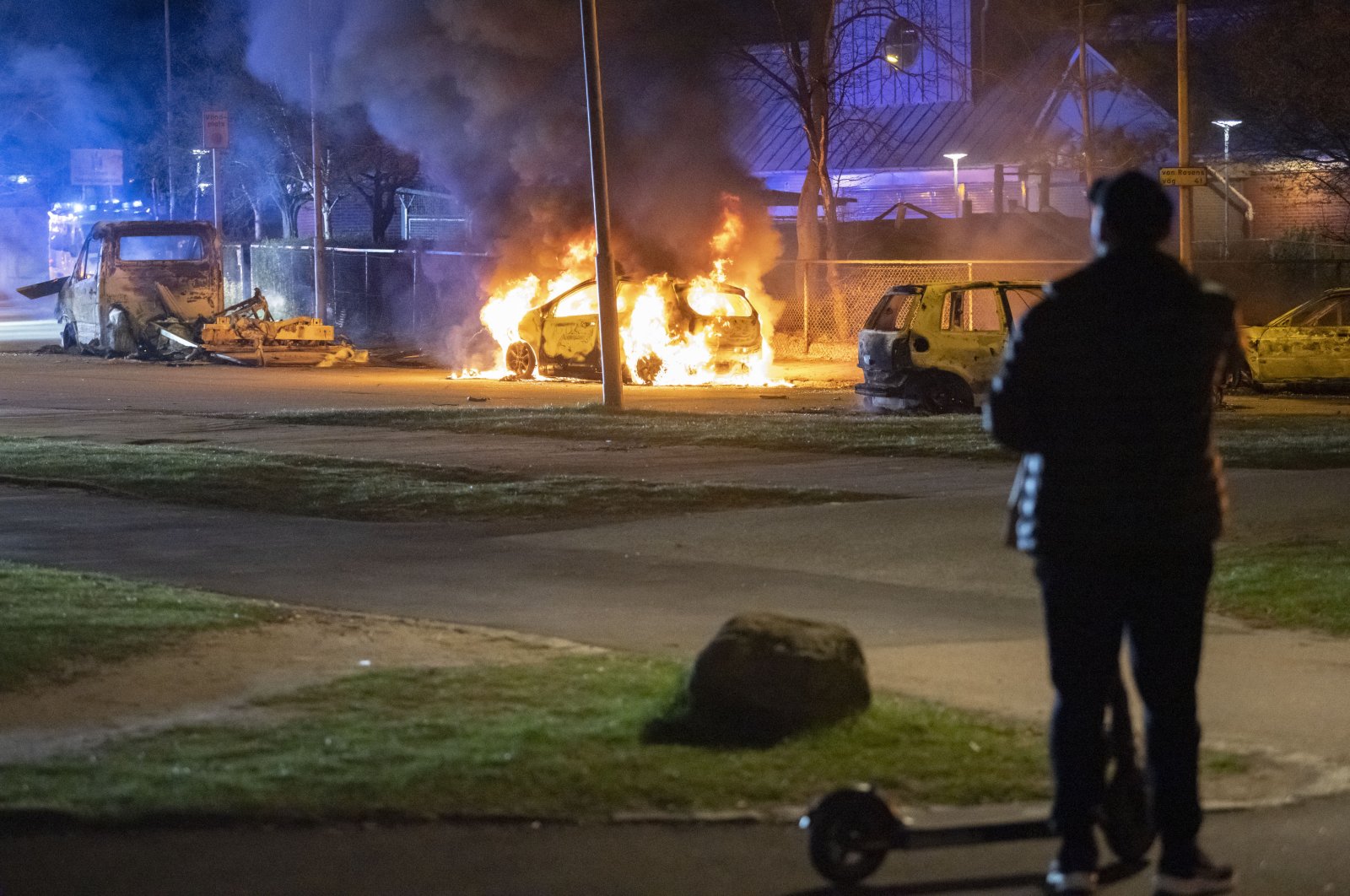 A man looks at burning cars after protests broke out at Rosengard in Malmo, Sweden, early Monday, April 17, 2022. The protests broke out following Danish far-right politician Rasmus Paludan’s burning of the Quran and other planned Quran burnings in various Swedish cities and towns since Thursday. (AP Photo)
