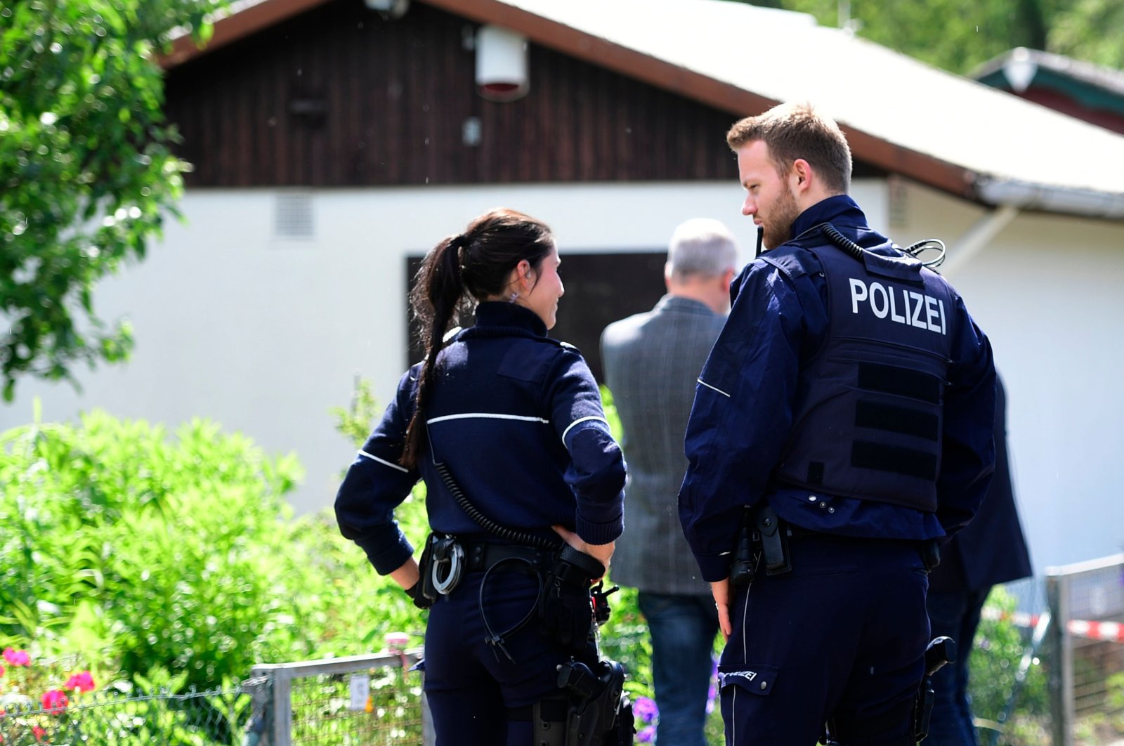 Police officers stand in front of a summer house, where sexual abuse of children, aged 5, 10 and 12 years old, are suspected to have taken place in Muenster, western Germany, June 6, 2020. (AFP Photo)