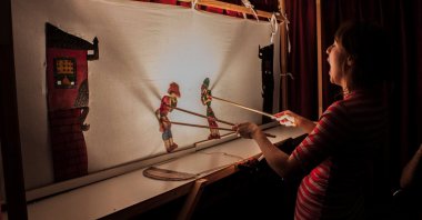 Ada Burke performs a shadow play with the characters Karagöz and Hacivat. (Courtesy of YEE London)