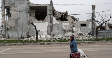 A local resident walks past a building destroyed during the Ukraine-Russia conflict in the southern port city of Mariupol, Ukraine, April 19, 2022. (Reuters Photo)