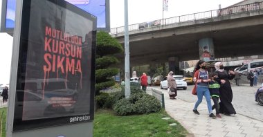 People walk by a billboard reading "Don't Fire On Happiness" in Trabzon, northern Turkey, April 20, 2022. (DHA Photo)
