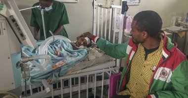 In this photo provided anonymously, Rahwa Mehari, 4, is comforted by her father, who says she first suffered from malnutrition and medical records show then developed a cerebral tuberculoma, at the Ayder Referral Hospital in Mekele in the Tigray region of northern Ethiopia, Oct. 4, 2021. (AP Photo, File)