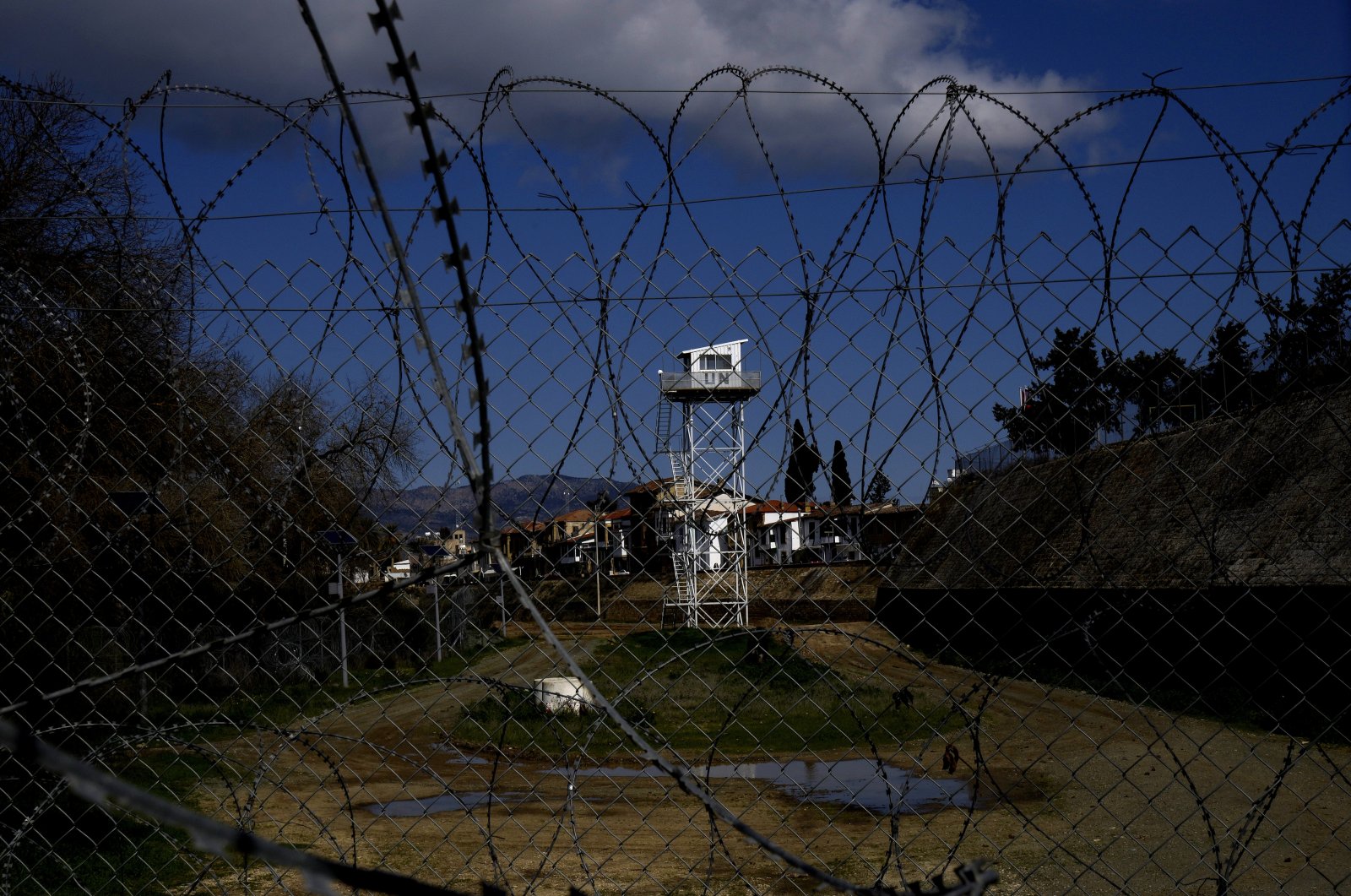 A U.N. tower guard post is seen behind barbed wires inside the U.N.-controlled buffer zone between the Greek Cypriot administration and the Turkish Republic of Northern Cyprus in the divided capital Nicosia, Cyprus, Thursday, Feb. 10, 2022. (AP File Photo)