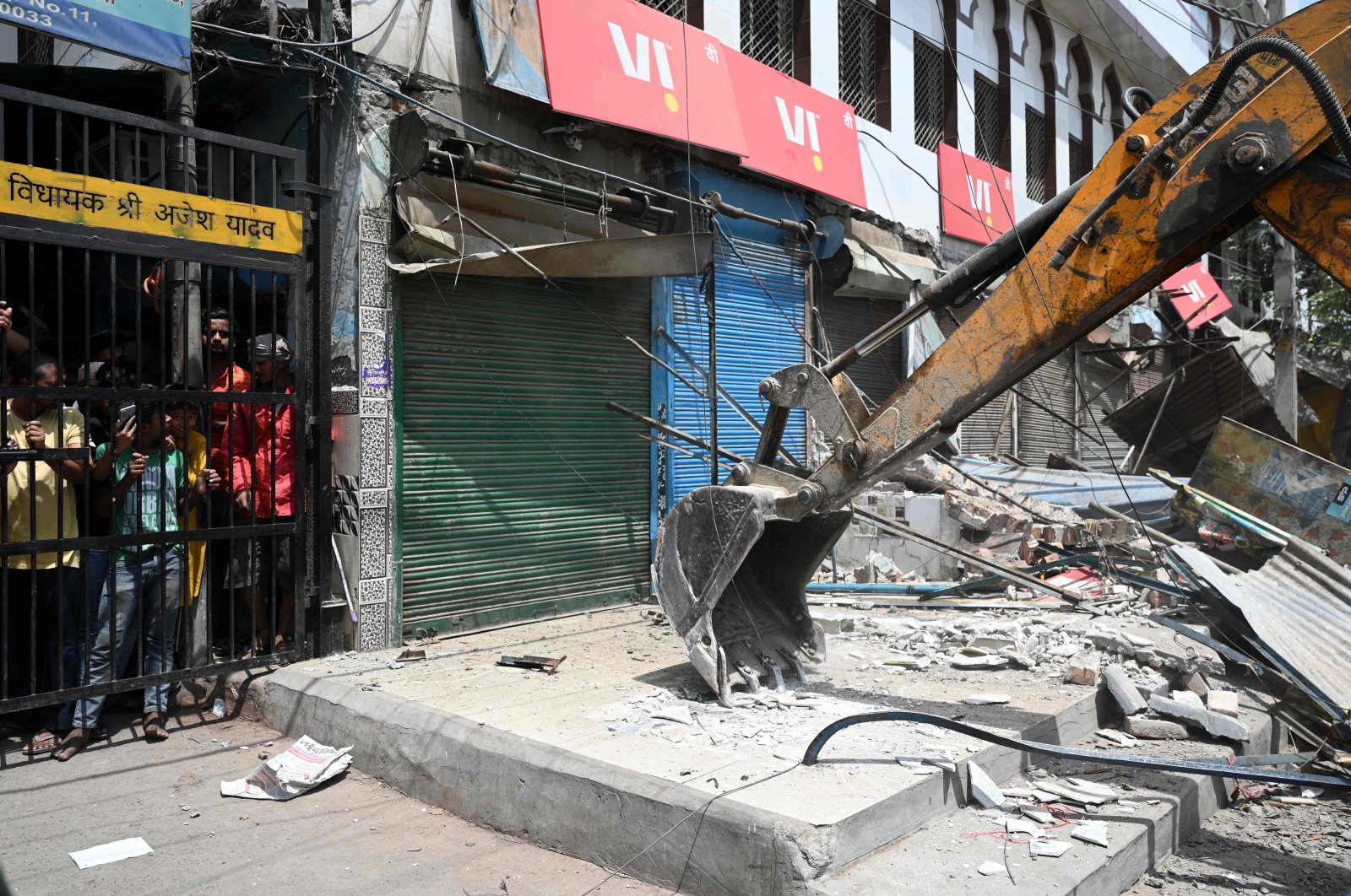 Residents watch as a bulldozer demolishes an illegal structure in a residential area during an anti-encroachment drive following clashes between members of two communities in Jahangirpuri, New Delhi, India, April 20, 2022. (AFP Photo)