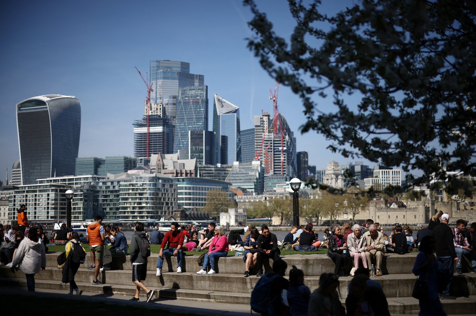 People relax near the bank of the River Thames during sunny weather in central London, Britain, April 16, 2022. (Reuters Photo)