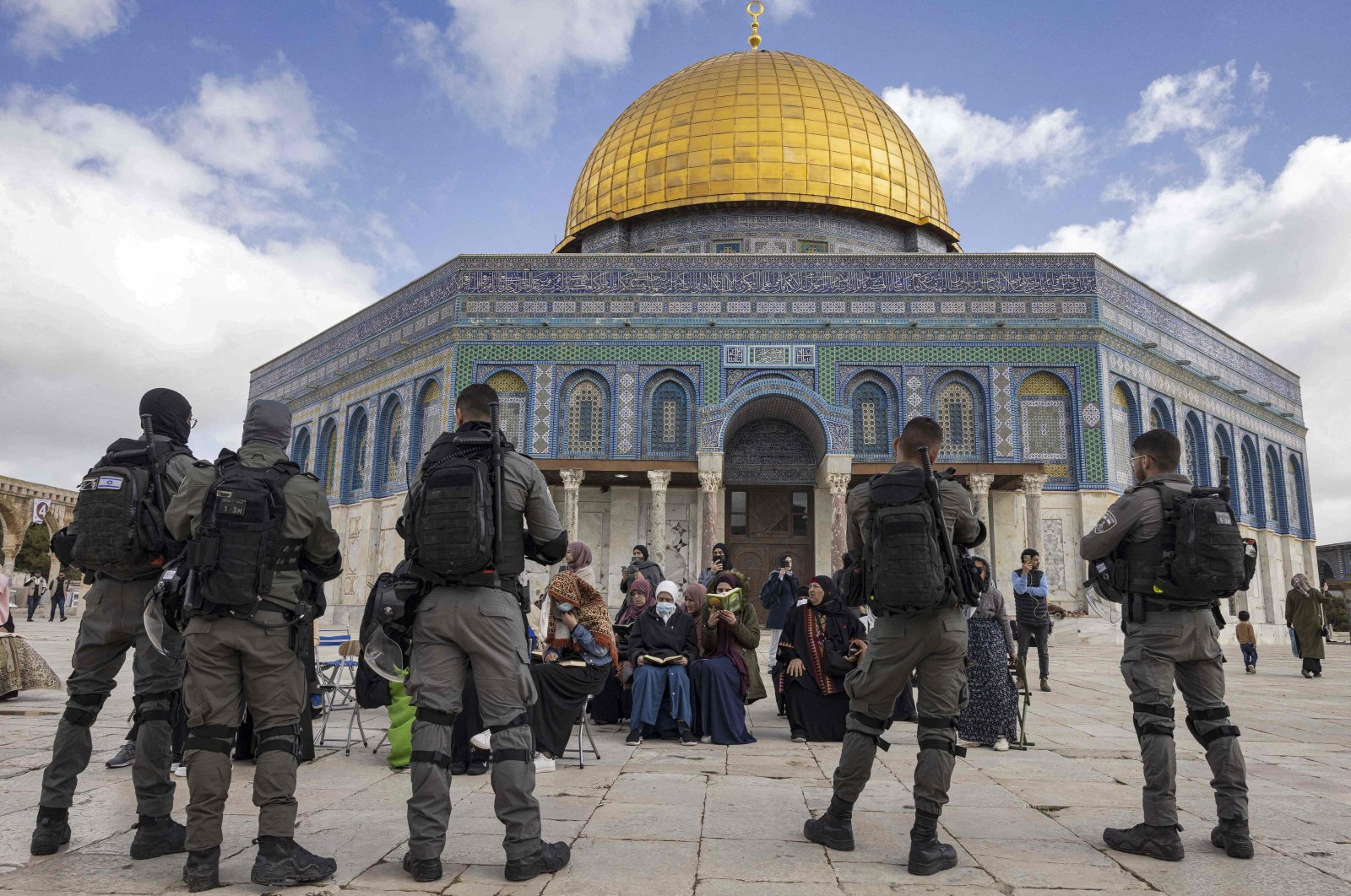 Israeli police stand in front of Muslim women praying in front of the Dome of the Rock as a group of Jewish people visit the Temple Mount at Al-Aqasa Mosque complex in occupied East Jerusalem, Palestine, April 20, 2022. (AFP Photo)