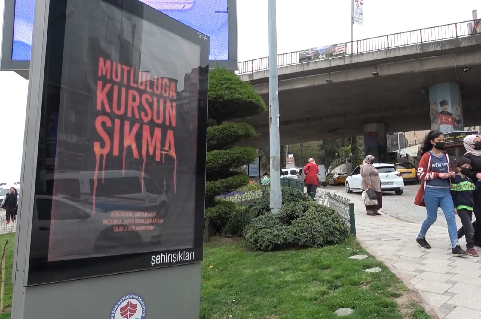 People walk by a billboard reading &quot;Don&#039;t Fire On Happiness&quot; in Trabzon, northern Turkey, April 20, 2022. (DHA Photo)