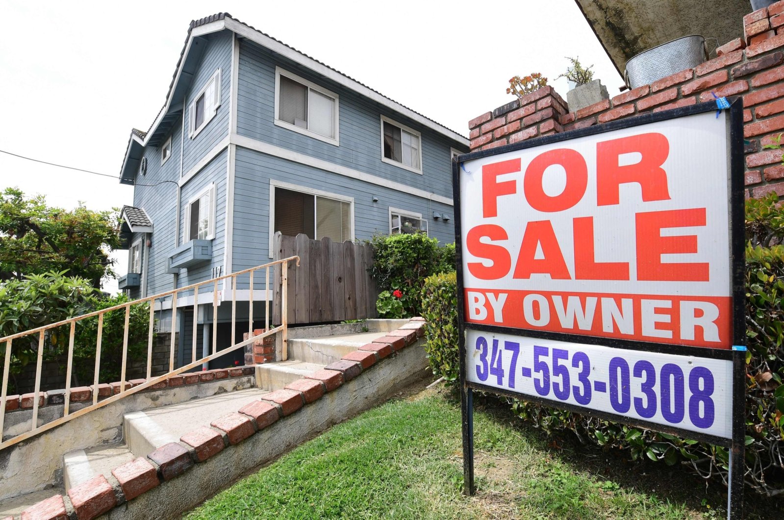 A &quot;For Sale by Owner&quot; sign is posted in front of a property in Monterey Park, California, U.S., April 29, 2020. (AFP Photo)