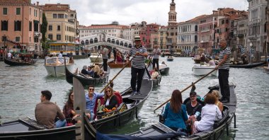 Tourists enjoy a gondola ride on the Grand Canal by the Rialto bridge in Venice, Italy, Sept. 18, 2021. (AFP Photo)