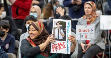 A woman waits with a sign for Canadian Prime Minister Justin Trudeau as he meets members of the Muslim community during a visit to the International School of Cambridge, Ontario, Canada, April 20, 2022. (Reuters Photo)