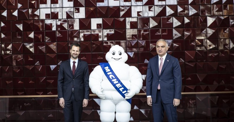 Gwendal Poullennec (L), International Director of Michelin Guides, and Mehmet Nuri Ersoy (R), Minister of Culture and Tourism, pose for a photo together with the Michelin mascot, in Istanbul, Turkey, April 21, 2022. (AA Photo)