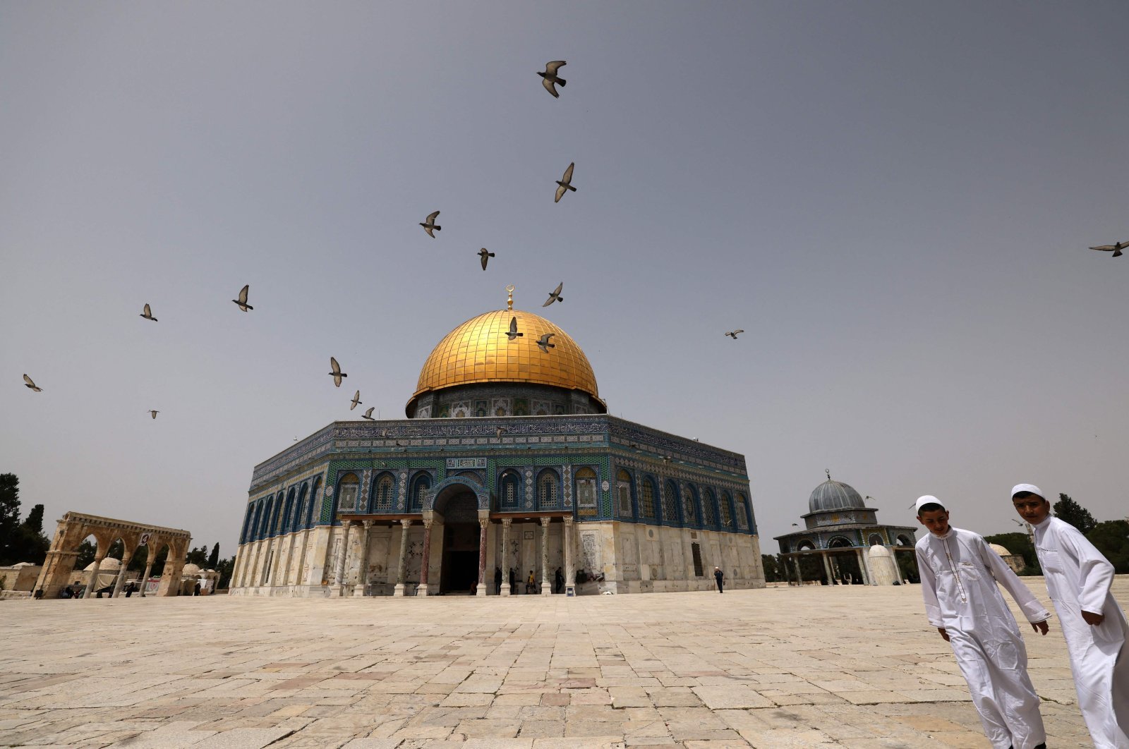 Palestinian Muslims walk in front of the Dome of Rock at the Al-Aqsa compound in Jerusalem&#039;s Old City, occupied Palestine, April 17, 2022. (AFP Photo)