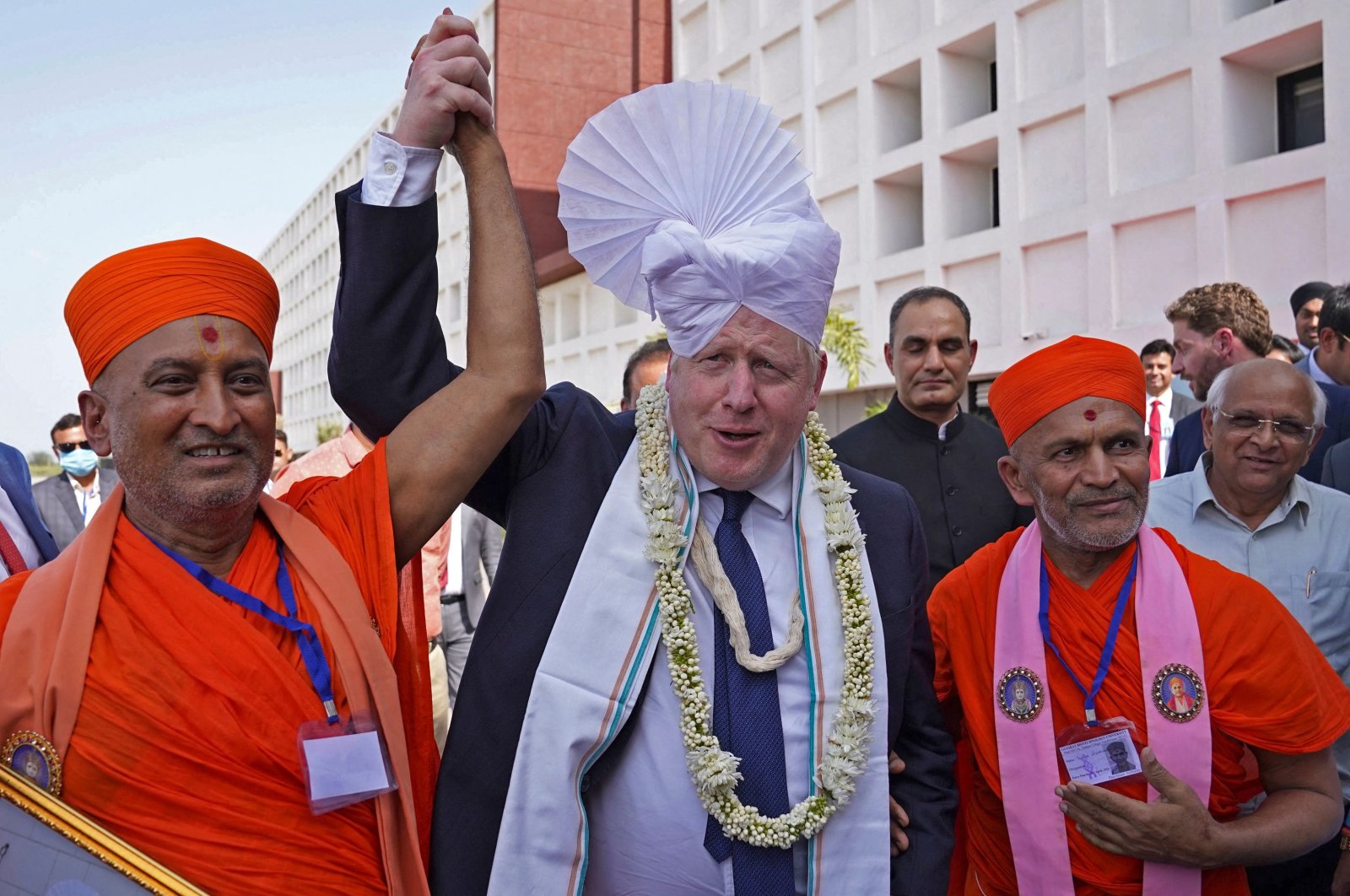 Britain&#039;s Prime Minister Boris Johnson (C) gets a traditional turban tied on his head upon his arrival at the Gujarat Biotechnology University in Gandhinagar on April 21, 2022. (AFP Photo)