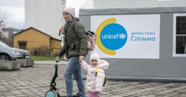 A woman walks with a small girl outside a UNICEF office. Manuel Fontaine, UNICEF director for emergency operations, and Afshan Khan, UNICEF regional director for Europe and Central Asia, together with Murat Sahin, UNICEF Representative in Ukraine, visited the Spilno center, Lviv, Ukraine, March 31, 2022. (Photo courtesy of UNICEF Turkey)