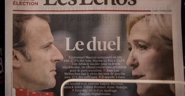 A French newspaper shows the two candidates for the second round of the French presidential election on display inside a kiosk in Paris, France, 11 April 2022. (EPA)