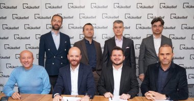 Mükellef founder Okan Şafak (bottom 2nd R), Ihsan Elgin (bottom R), a member of the board at Finberg, and other executives and investors during a signing ceremony for the latest funding. (Courtesy of Mükellef)