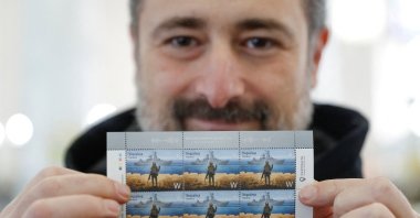 A man holds postal stamps showing a Ukrainian service member and the Russian Moskva warship at the headquarters of the Ukrainian postal service in Kyiv, Ukraine, April 14, 2022. (Reuters Photo)