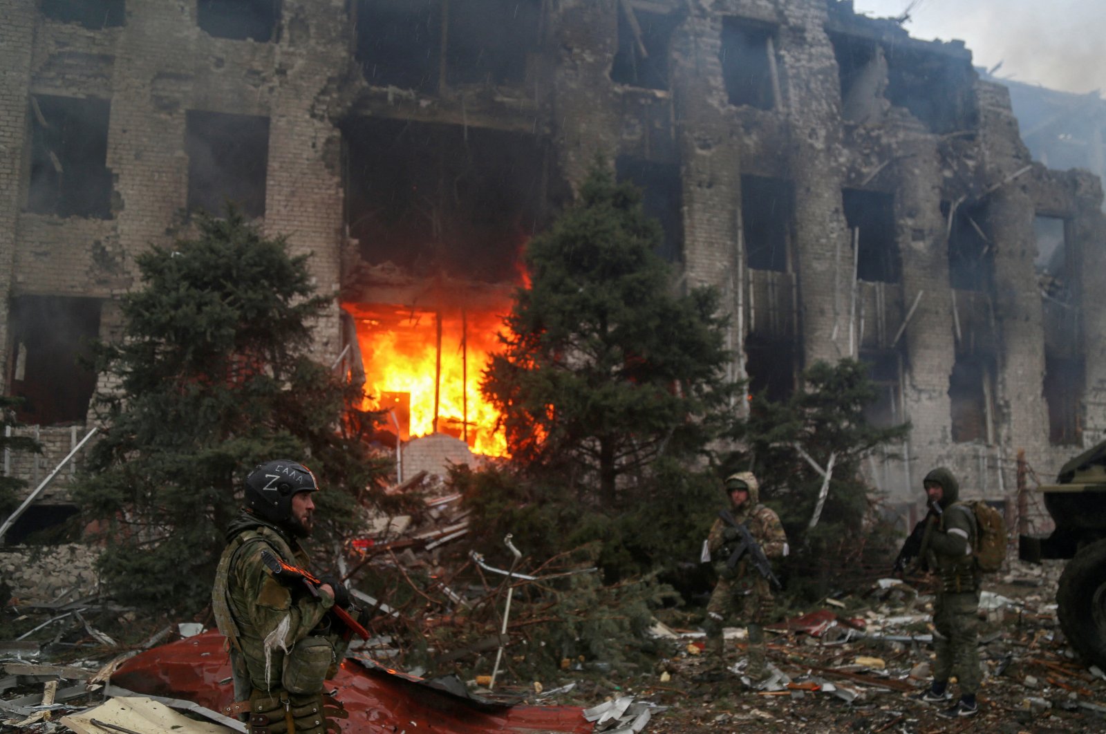 Service members of pro-Russian troops, including fighters of the Chechen special forces unit, stand in front of the destroyed administration building of Azovstal Iron and Steel Works during the Ukraine-Russia conflict in the southern port city of Mariupol, Ukraine, April 21, 2022. (Reuters Photo)