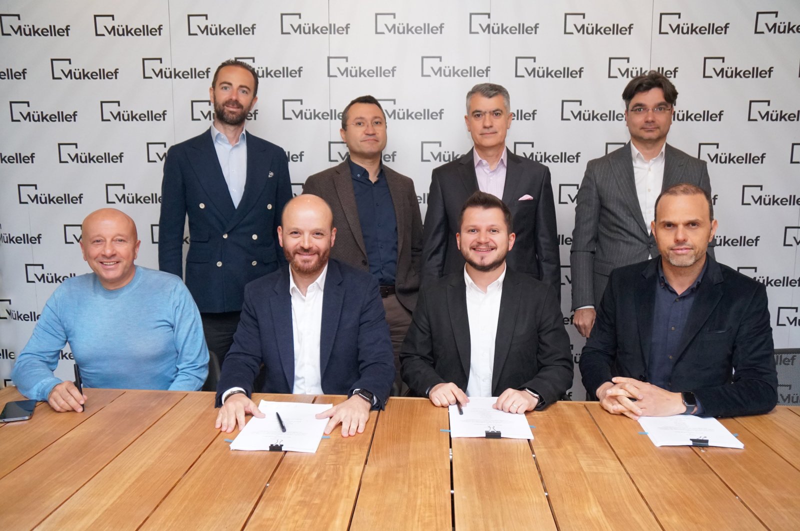 Mükellef founder Okan Şafak (bottom 2nd R), Ihsan Elgin (bottom R), a member of the board at Finberg, and other executives and investors during a signing ceremony for the latest funding. (Courtesy of Mükellef)