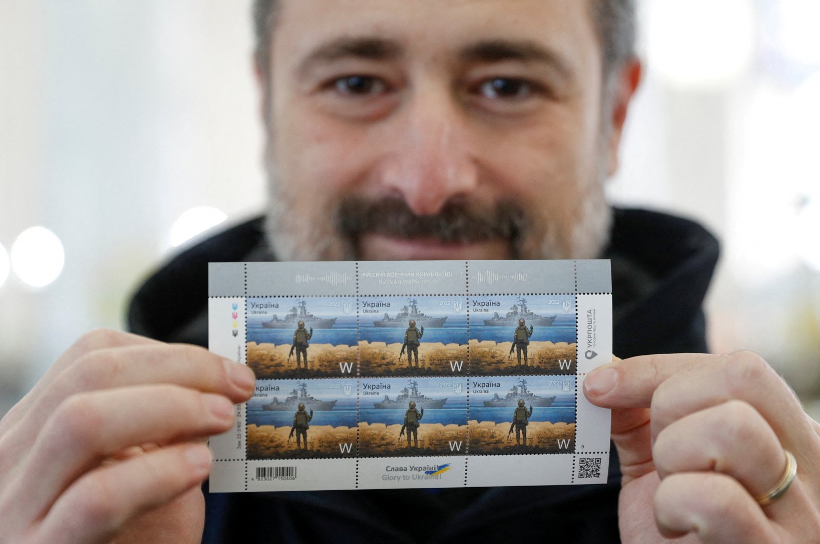 A man holds postal stamps showing a Ukrainian service member and the Russian Moskva warship at the headquarters of the Ukrainian postal service in Kyiv, Ukraine, April 14, 2022. (Reuters Photo)