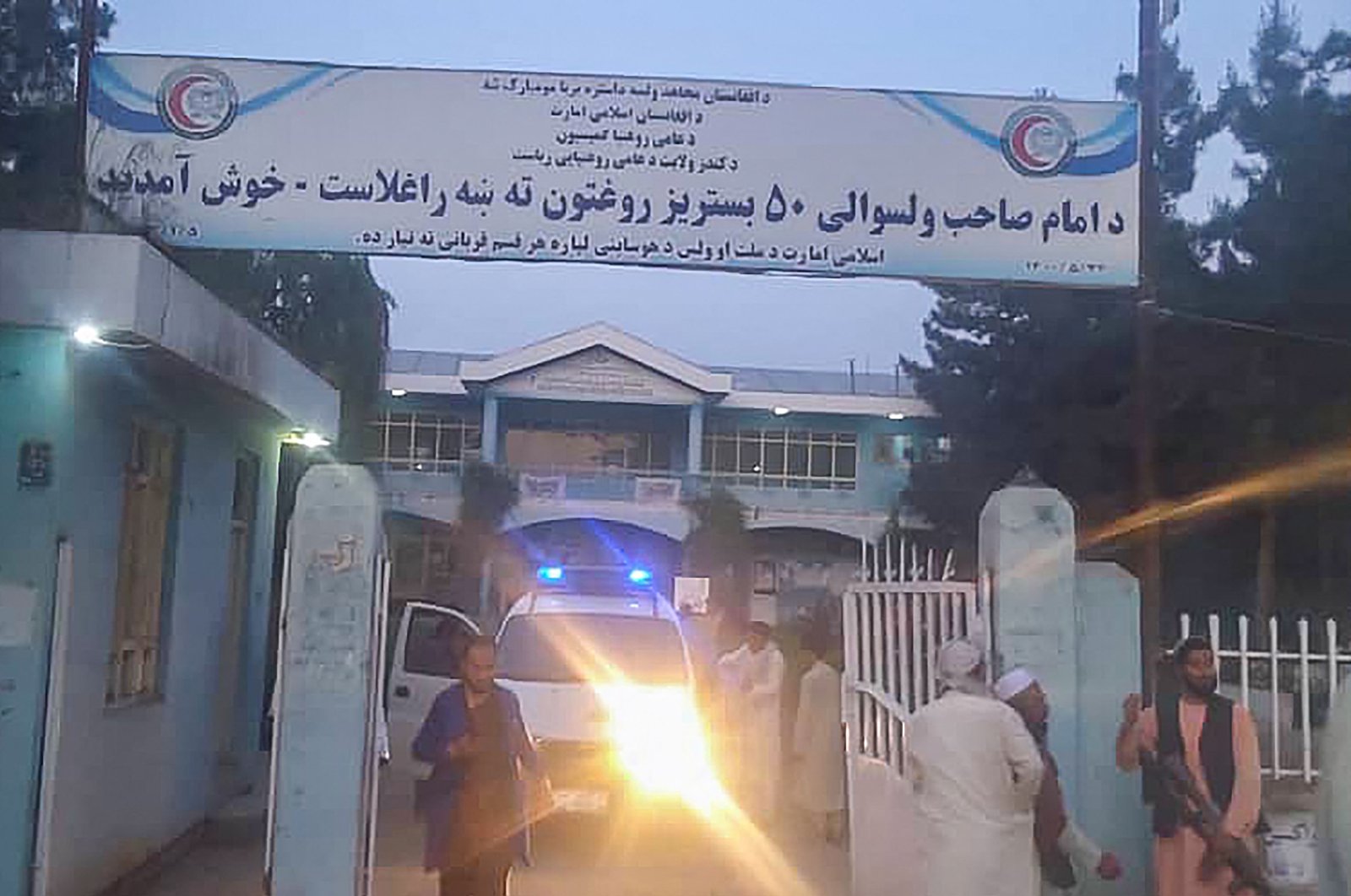 Taliban fighters and medical staff stand outside the gate of a hospital as they prepare to attend to the casualties after an explosion at the Imam Sahib district in Kunduz province, Afghanistan, April 22, 2022. (AFP Photo)