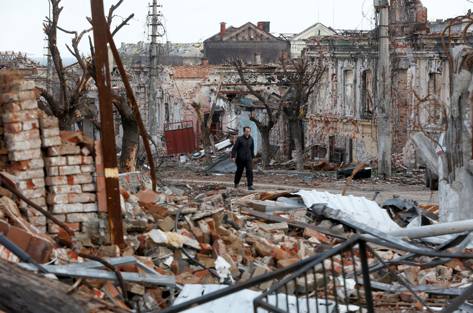 A man walks near damaged buildings in the course of the Ukraine-Russia conflict in the southern port city of Mariupol, Ukraine, April 22, 2022. (Reuters Photo)