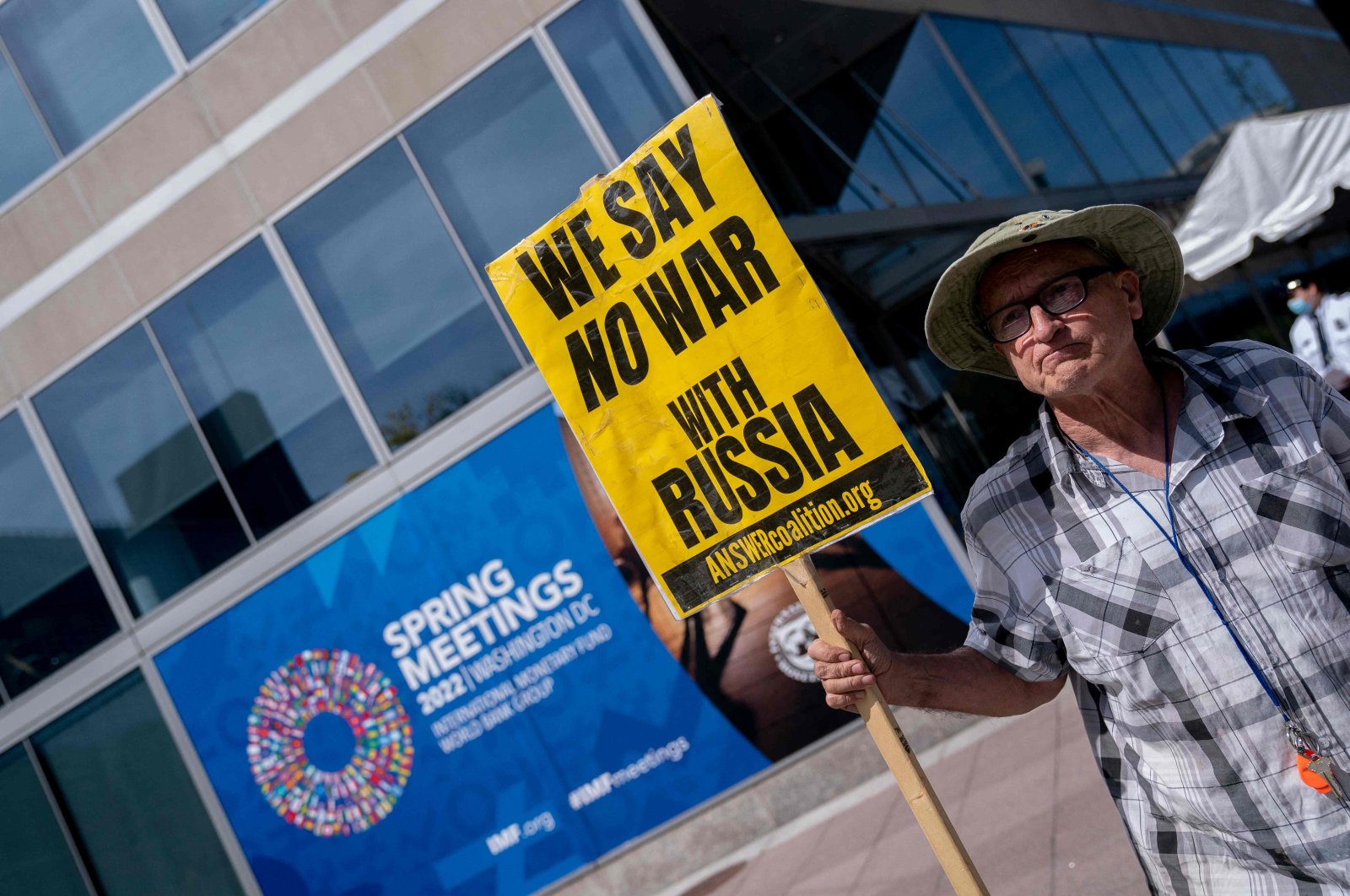 A demonstrator carries a sign against the Russian invasion of Ukraine, outside the IMF headquarters in Washington, D.C., U.S., April 22, 2022. (AFP Photo)