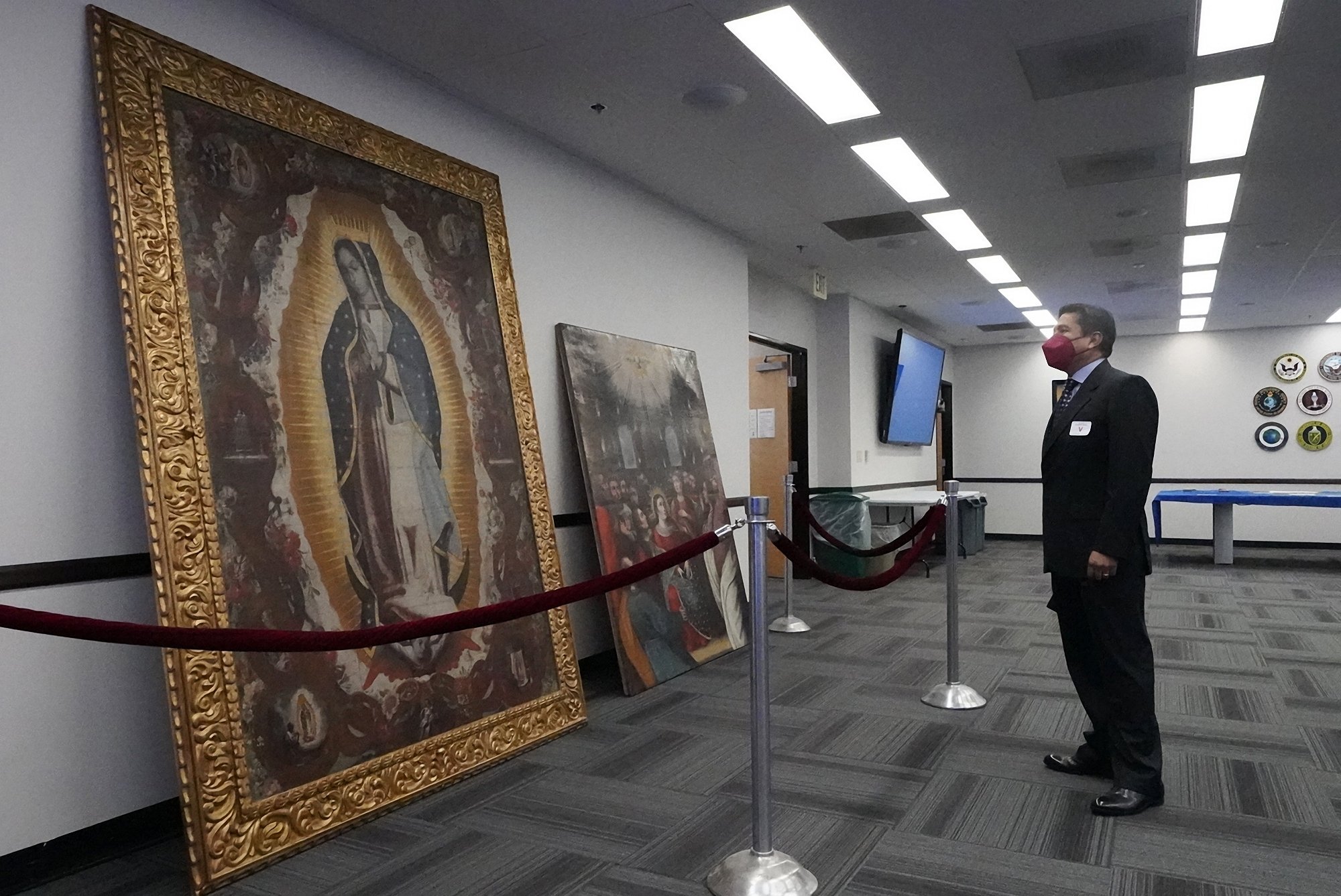 Jose Luis Chavez Gonzales, Consul General, Peruvian Consulate in Los Angeles, admires recovered Peruvian paintings following investigations by the FBI's Art Crime Team at the FBI headquarters, 