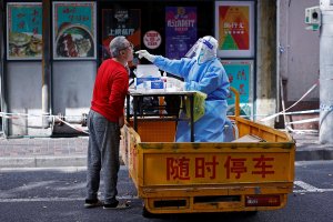 A medical worker in a protective suit collects a swab from a resident for nucleic acid testing, amid the coronavirus disease (COVID-19) outbreak in Shanghai, China, April 22, 2022. (Reuters Photo)
