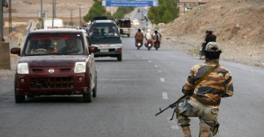 A Taliban fighter kneels down while on guard at a road checkpoint in Kandahar, Afghanistan, April 23, 2022. (AFP)