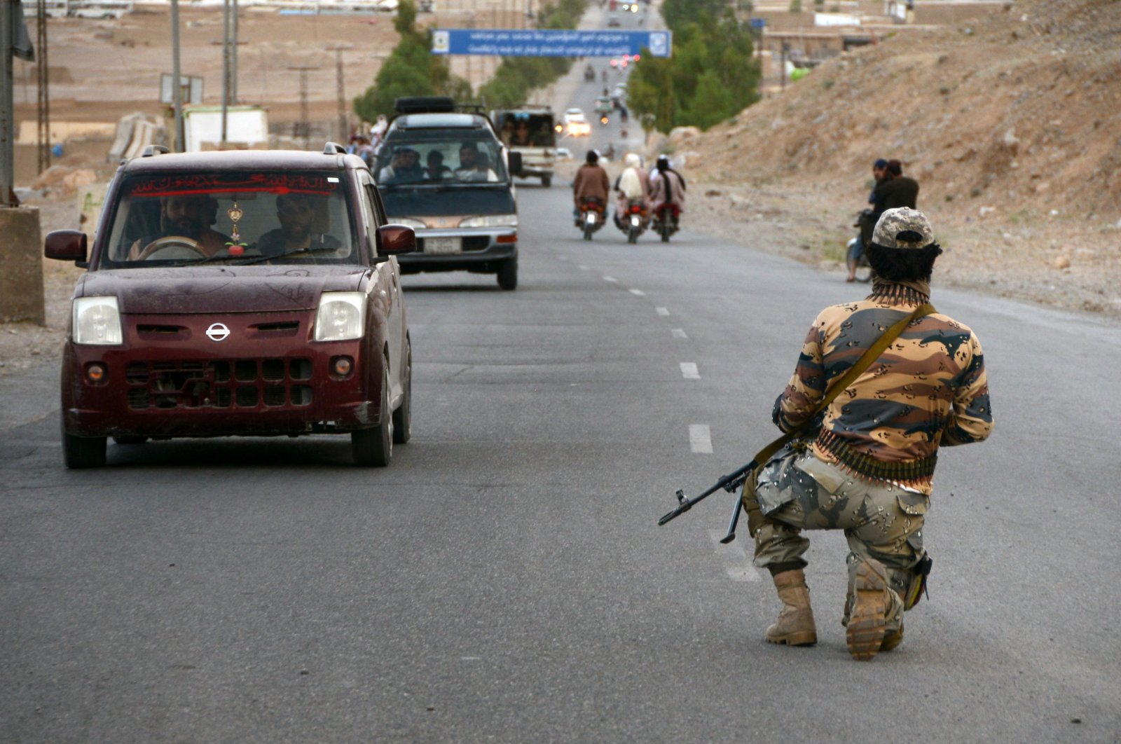 A Taliban fighter kneels down while on guard at a road checkpoint in Kandahar, Afghanistan, April 23, 2022. (AFP)
