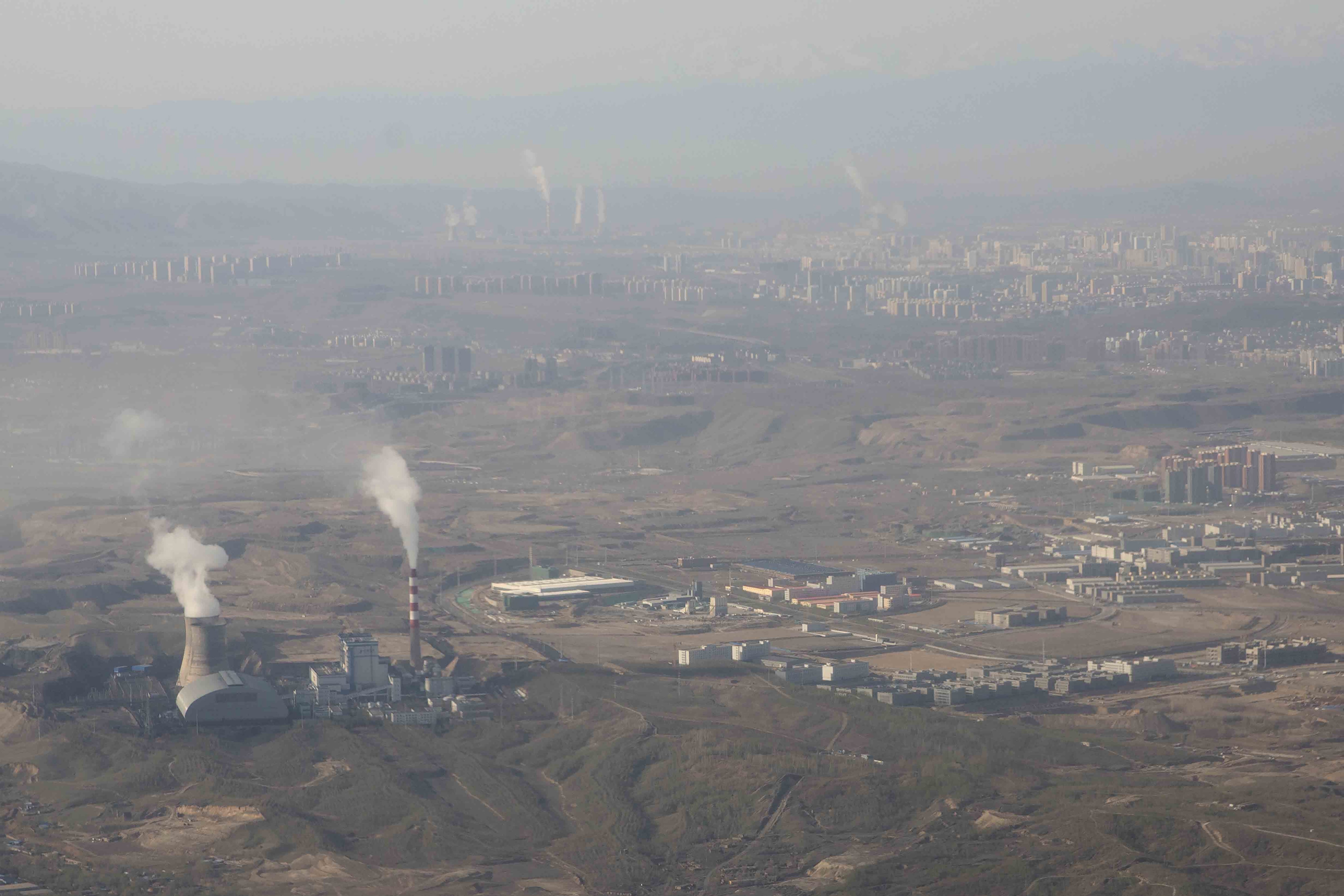 Smoke and steam rise from towers at the coal-fired Urumqi Thermal Power Plant as seen from a plane in Urumqi in western China&#039;s Xinjiang Uyghur Autonomous Region, April 21, 2021. (AP Photo)