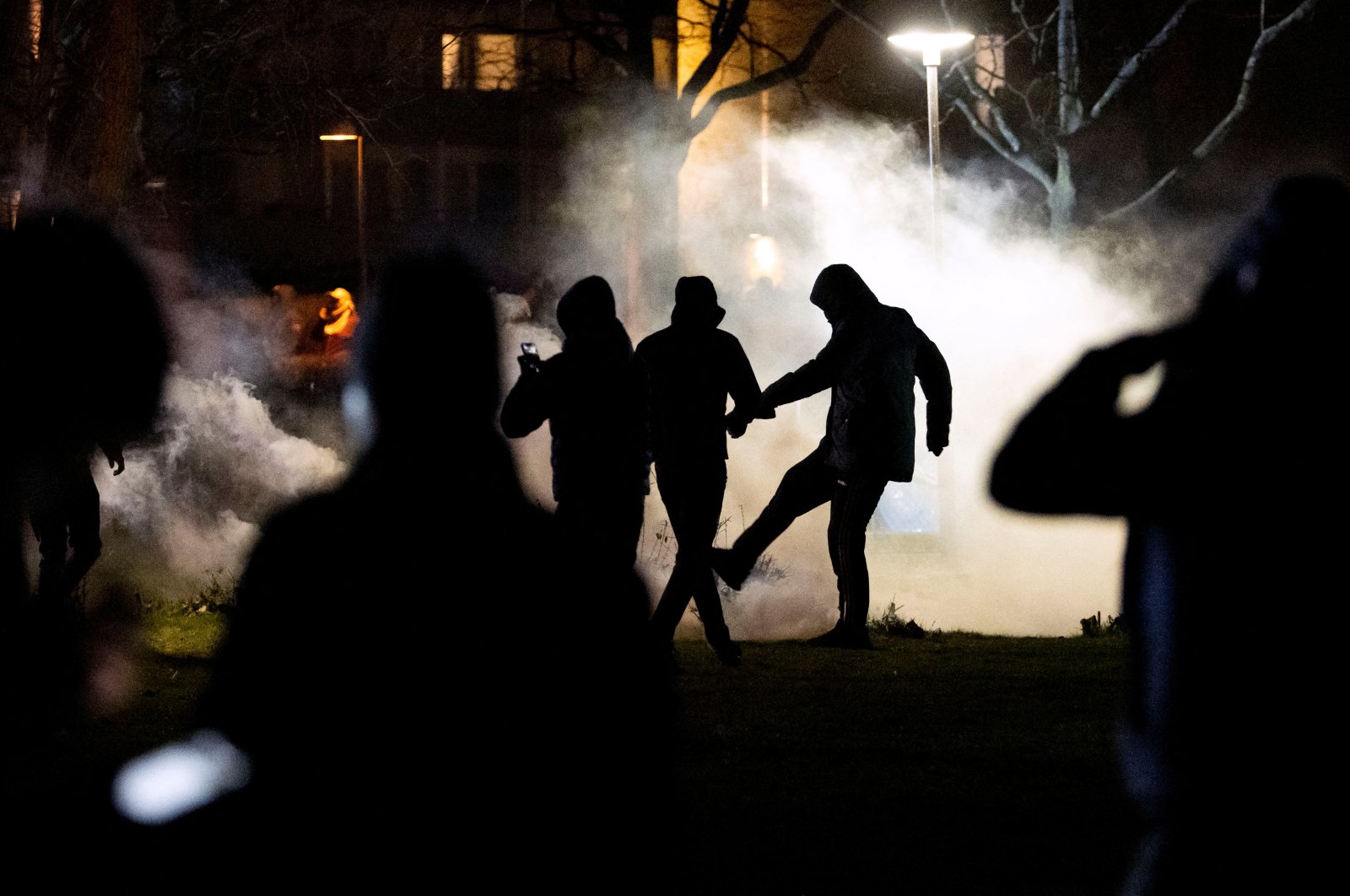 Protesters stand amid tear gas fired by the police in Rosengard district, following Quran burnings that caused riots in several Swedish towns over the Easter weekend, Malmo, Sweden, April 18, 2022. (Reuters Photo)