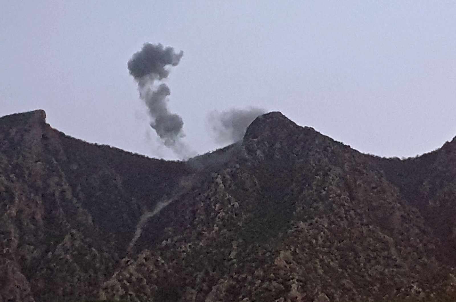 A picture taken on April 17, 2022 shows smoke billowing from behind the mountains of Matin following a Turkish operation targeting PKK terrorists in northern Iraq. (AFP)