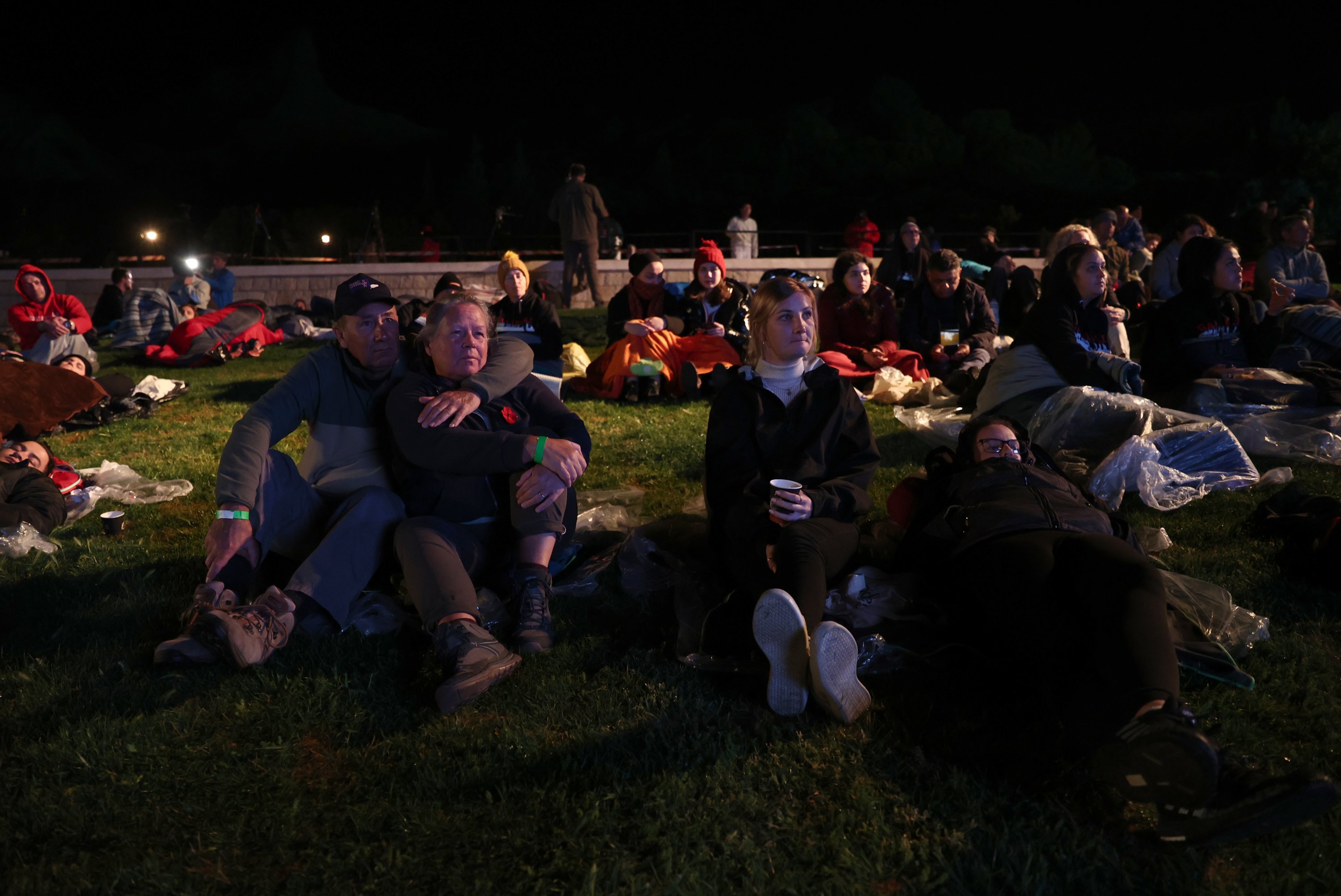 People watching documentaries about the battle while waiting for the dawn service at Anzac Cove, in Çanakkale, western Turkey, April 25, 2022. (AA Photo)