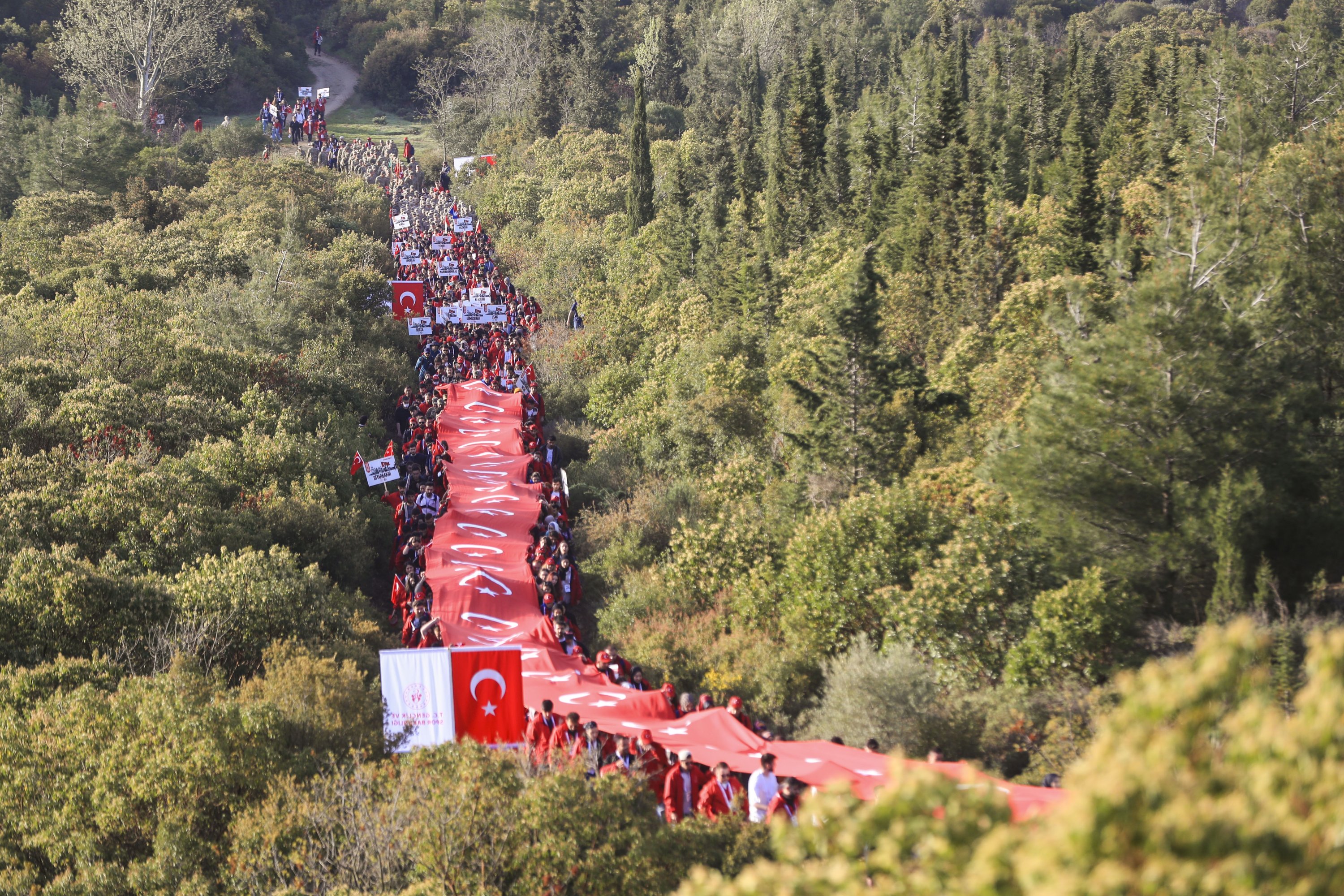 Participants carry a giant Turkish flag during a march to remember fallen troops, in Çanakkale, western Turkey, April 25, 2022. (AA Photo)