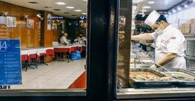 A worker stands behind a counter in a partially empty restaurant on famous Istiklal Avenue in Istanbul, Turkey, Dec. 15, 2020. (AFP Photo)