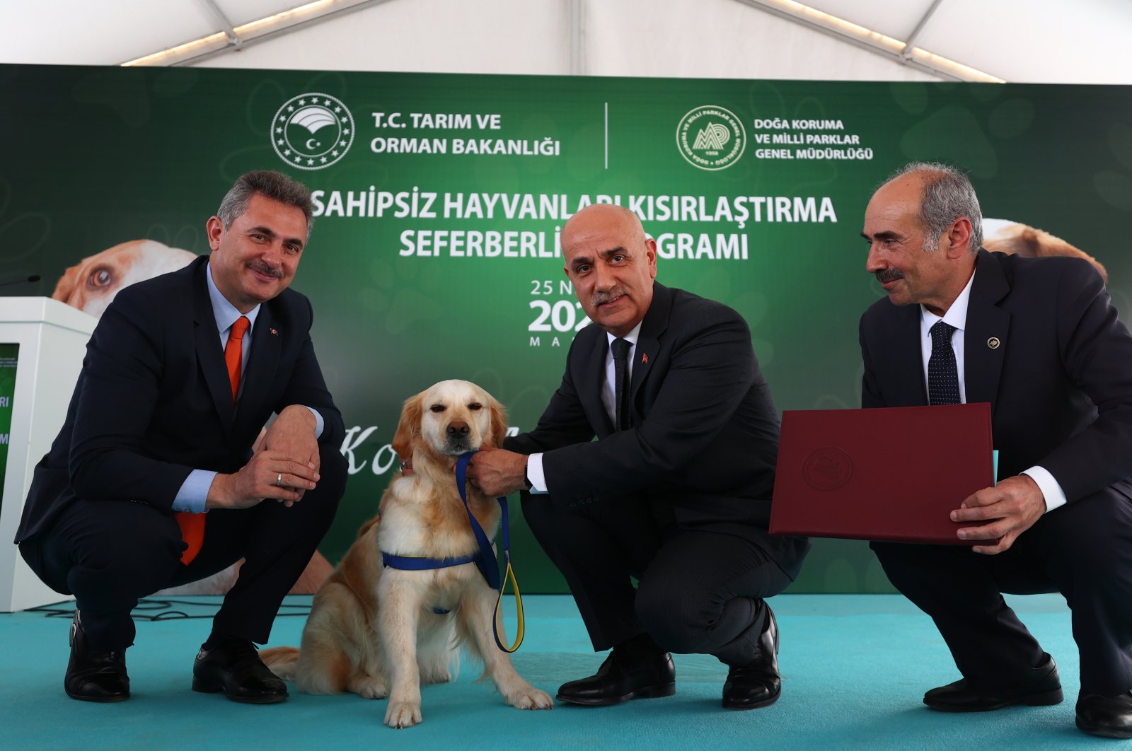 Agriculture and Forestry Minister Vahit Kirişçi (C) pets a dog he adopted during the event, in the capital Ankara, Turkey, April 25, 2022. (AA PHOTO)