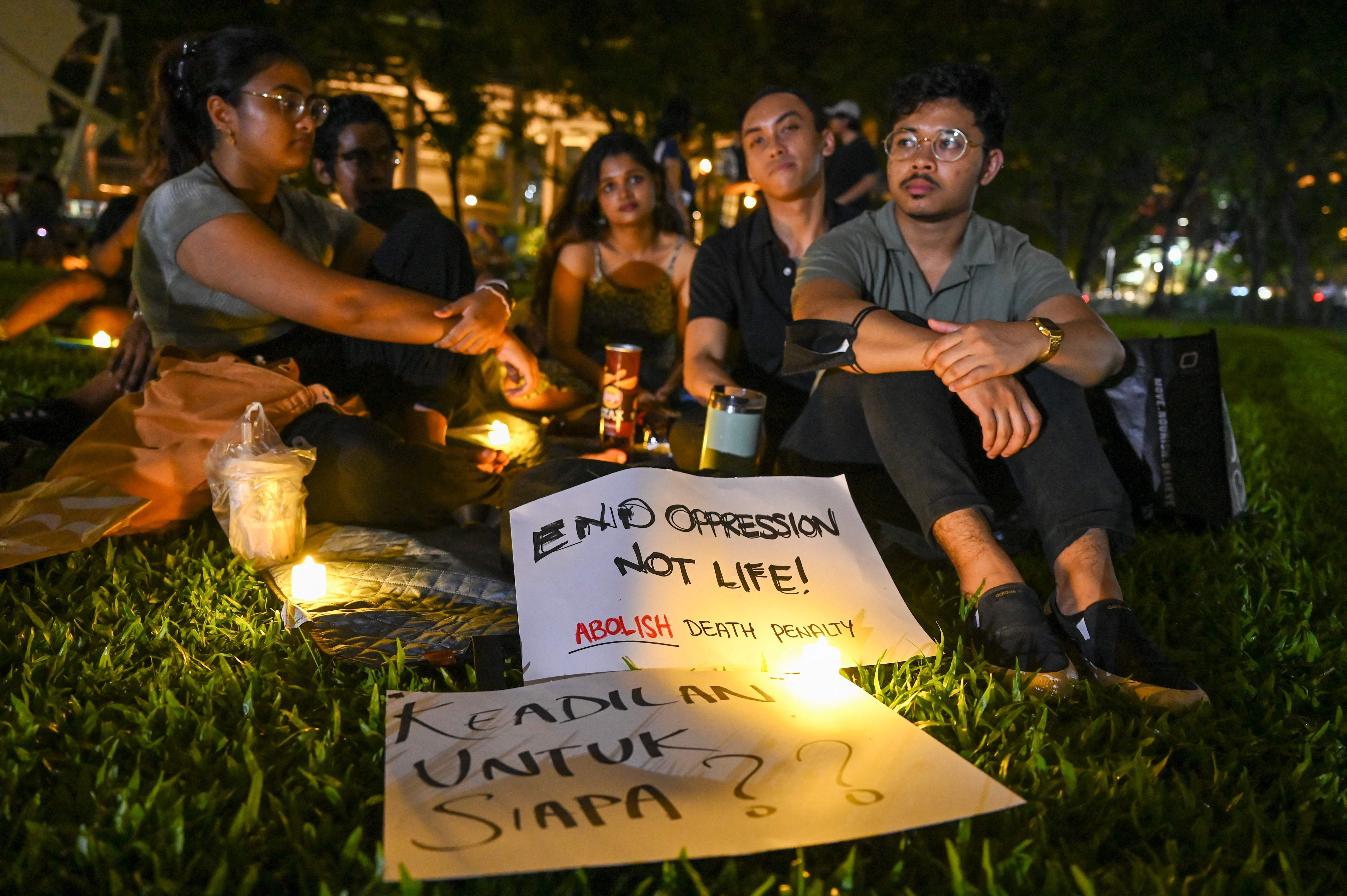 People display placards and lights during a vigil for Malaysian national Nagaenthran K. Dharmalingam, sentenced to death for trafficking heroin into Singapore, at Speakers corner in Singapore, April 25, 2022. (AFP Photo)
