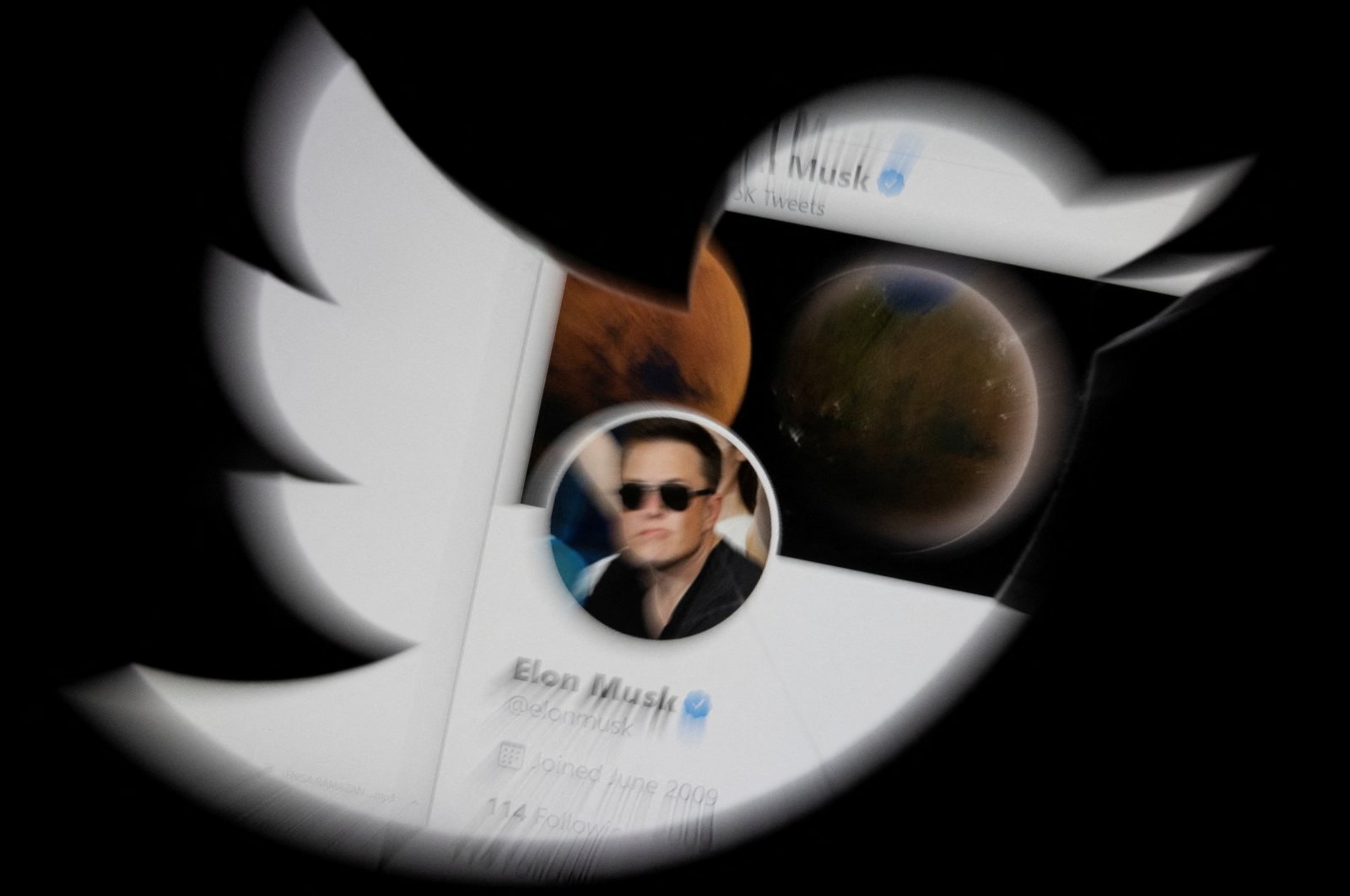 Elon Musk&#039;s Twitter account is seen through the Twitter logo in this illustration, April 25, 2022. (REUTERS Photo)