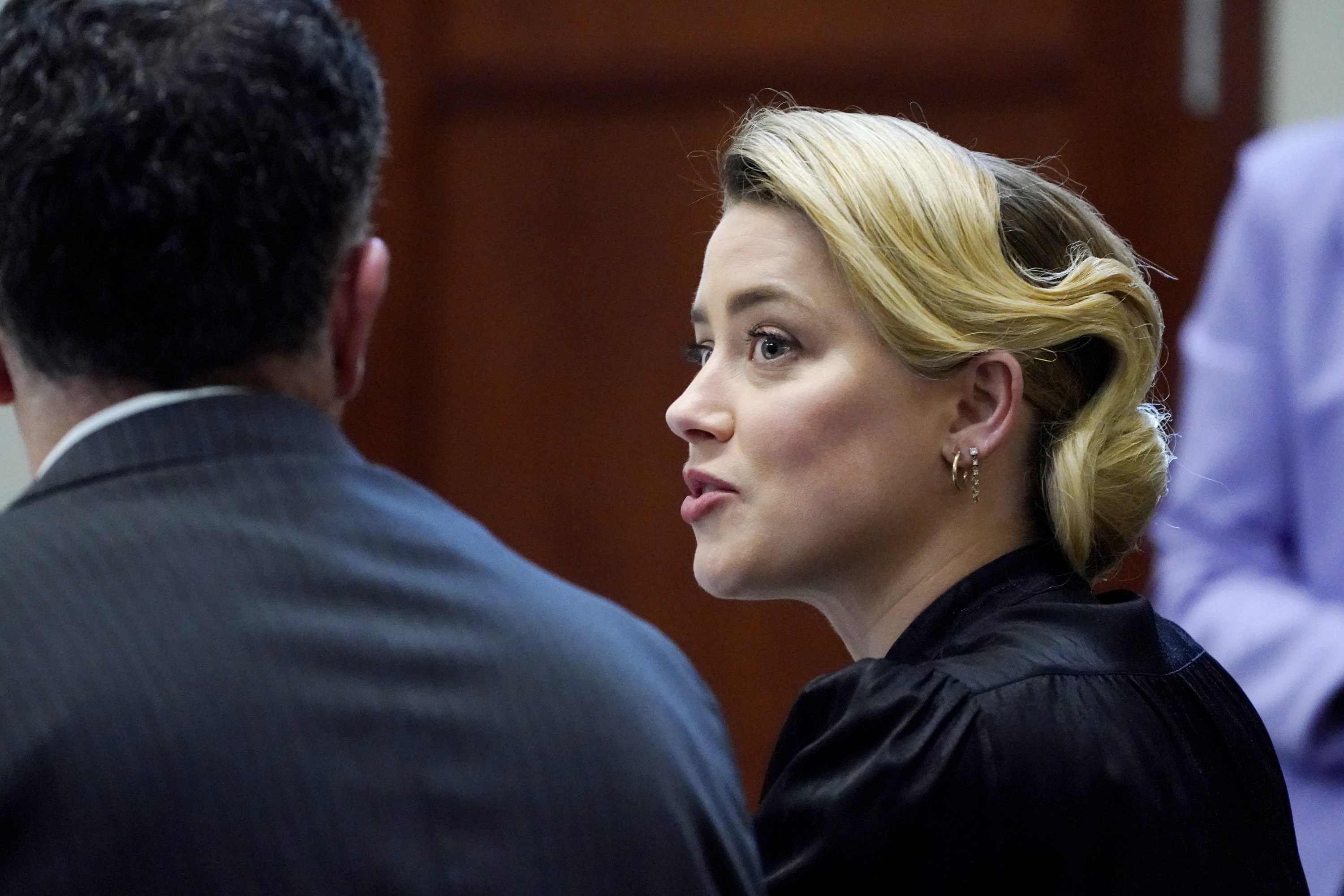 Aktris Amber Heard berbicara dengan pengacaranya di ruang sidang di Fairfax County Circuit Courthouse di Fairfax, Va., Senin, 25 April 2022. (AP)