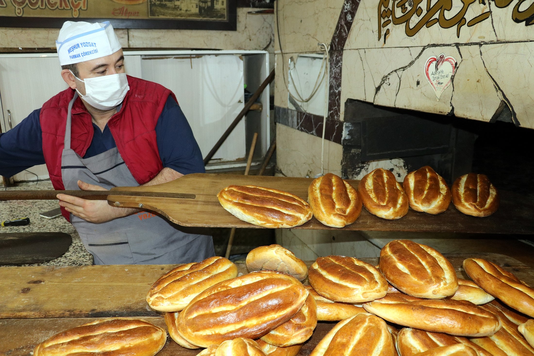 Seorang tukang roti mengeluarkan roti dari oven, Yozgat, Turki, 22 April 2022. (AA Photo)