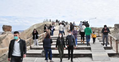 People wearing protective masks against COVID-19 walk on a walkway in the historic Cappadocia region, in Nevşehir, central Turkey, April 26, 2022. (DHA Photo)