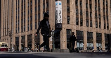 People walk by a Twitter logo at the company headquarters in downtown San Francisco, California, U.S., April 25, 2022. (Reuters Photo)